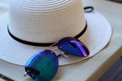 A hat and a pair of sunglasses. The Thai for "a hat and a pair of sunglasses" is "หมวกและแว่นกันแดด".