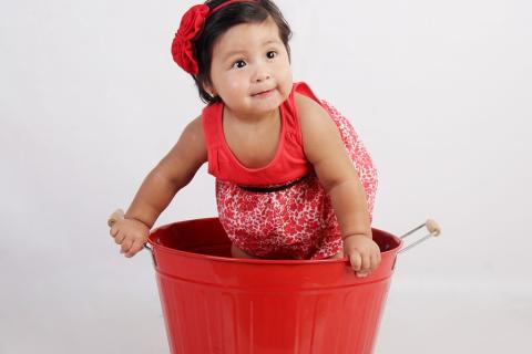A girl and a red bucket. The Thai for "a girl and a red bucket" is "เด็กผู้หญิงและถังน้ำสีแดง".