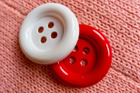 A red and a white button. The Thai for "a red and a white button" is "กระดุมสีแดงและสีขาว".