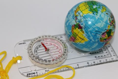 A compass and a globe. The Thai for "a compass and a globe" is "เข็มทิศและลูกโลก".