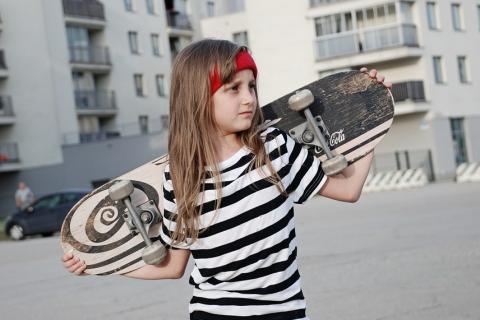 A girl and a skateboard. The Thai for "a girl and a skateboard" is "เด็กผู้หญิงและสเก็ตบอร์ด".