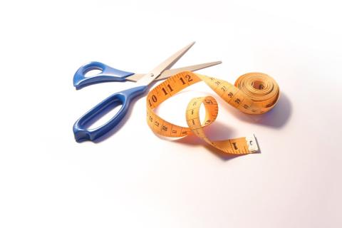 A pair of scissors and a tape measure. The Thai for "a pair of scissors and a tape measure" is "กรรไกรและสายวัด".