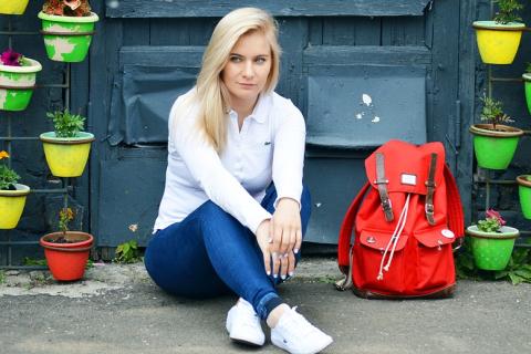 A woman and a red backpack. The Thai for "a woman and a red backpack" is "ผู้หญิงและเป้สีแดง".