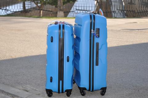 Two blue suitcases. The Thai for "two blue suitcases" is "กระเป๋าเดินทางสีน้ำเงินสองใบ".