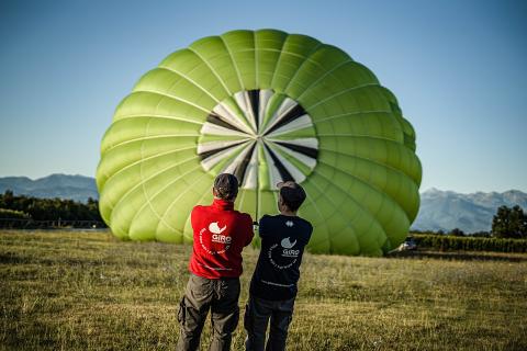 Two men and a green hot air balloon. The Thai for "two men and a green hot air balloon" is "ผู้ชายสองคนและบอลลูนสีเขียว".