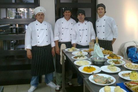 Four chefs. The Thai for "four chefs" is "พ่อครัวสี่คน".