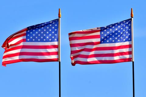 Two American flags. The Thai for "two American flags" is "ธงชาติอเมริกาสองผืน".