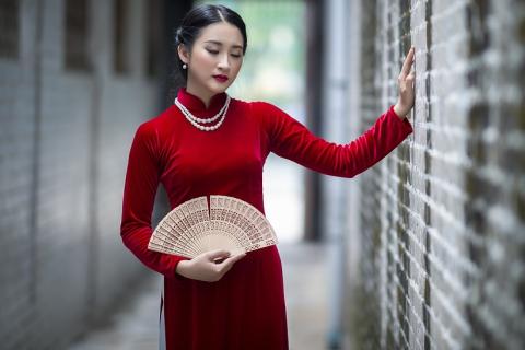 A woman in a red dress with a fan. The Thai for "a woman in a red dress with a fan" is "ผู้หญิงชุดแดงและพัด".