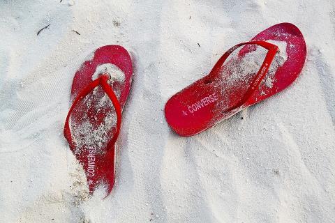 A pair of red sandals. The Thai for "a pair of red sandals" is "รองเท้าแตะสีแดงหนึ่งคู่".