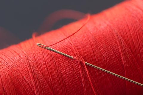 A needle and red thread. The Thai for "a needle and red thread" is "เข็มและด้ายแดง".
