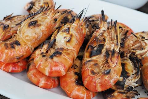 A plate of grilled shrimps. The Thai for "a plate of grilled shrimps" is "กุ้งเผาหนึ่งจาน".