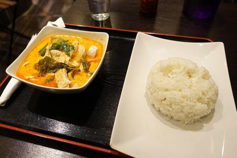A bowl of red curry chicken and a plate of rice. The Thai for "a bowl of red curry chicken and a plate of rice" is "แกงเผ็ดไก่หนึ่งชามและข้าวหนึ่งจาน".