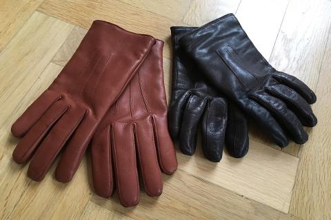 A pair of brown leather gloves and a pair of black leather gloves. The Thai for "a pair of brown leather gloves and a pair of black leather gloves" is "ถุงมือหนังสีน้ำตาลและถุงมือหนังสีดำ".