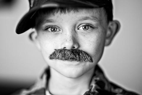 A boy with a fake mustache. The Thai for "a boy with a fake mustache" is "เด็กผู้ชายกับหนวดปลอม".