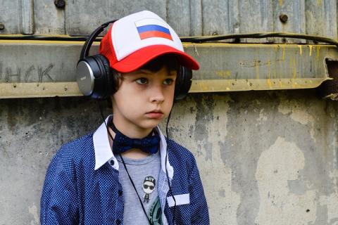 A boy with headphones and a cap. The Thai for "a boy with headphones and a cap" is "เด็กผู้ชายกับหูฟังและหมวกแก๊ป".