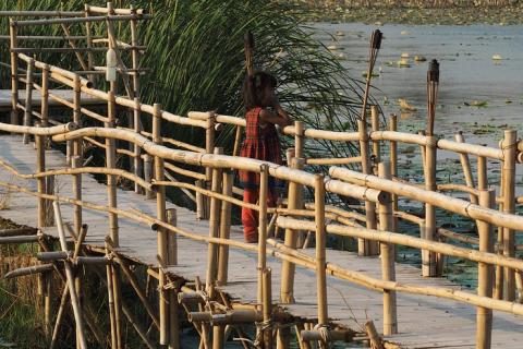 A girl on a wooden bridge. The Thai for "a girl on a wooden bridge" is "เด็กหญิงบนสะพานไม้".