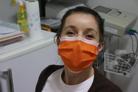 A nurse with an orange mask. The Thai for "a nurse with an orange mask" is "พยาบาลกับหน้ากากอนามัยสีส้ม".