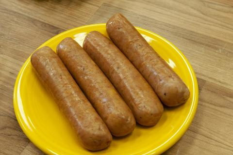 Four sausages on a yellow plate. The Thai for "four sausages on a yellow plate" is "ไส้กรอกสี่ชิ้นบนจานสีเหลือง".