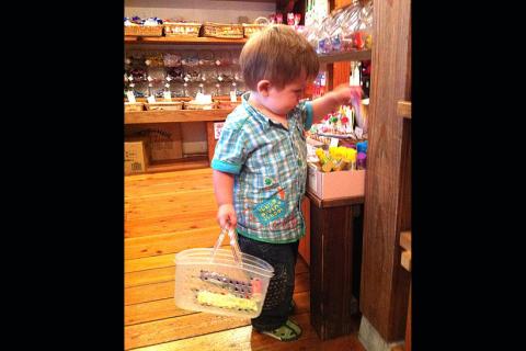 A boy in a candy store. The Thai for "a boy in a candy store" is "เด็กผู้ชายในร้านขายลูกอม".