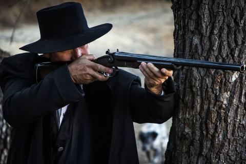 A man in black with a rifle. The Thai for "a man in black with a rifle" is "ชายชุดดำกับปืนยาว".