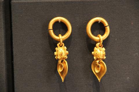 A pair of gold earrings. The Thai for "a pair of gold earrings" is "ตุ้มหูทองหนึ่งคู่".