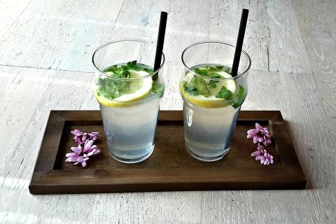 Two glasses of lemonade on a wooden tray. The Thai for "two glasses of lemonade on a wooden tray" is "น้ำมะนาวสองแก้วบนถาดไม้".
