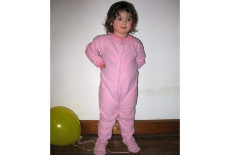A girl in pink pajamas. The Thai for "a girl in pink pajamas" is "เด็กผู้หญิงในชุดนอนสีชมพู".