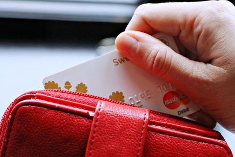 A credit card in a red wallet. The Thai for "a credit card in a red wallet" is "เครดิตการ์ดในกระเป๋าตังค์สีแดง".