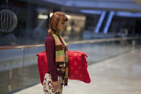 A short-haired woman with a red pillow. The Thai for "a short-haired woman with a red pillow" is "ผู้หญิงผมสั้นกับหมอนสีแดง".