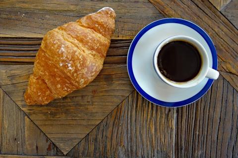 A croissant and a cup of coffee. The Thai for "a croissant and a cup of coffee" is "ครัวซองส์หนึ่งชิ้นกับกาแฟหนึ่งถ้วย".