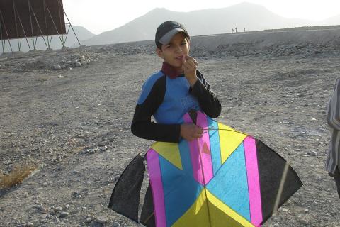 A boy with a kite. The Thai for "a boy with a kite" is "เด็กผู้ชายกับว่าว".