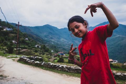 A girl in a red t-shirt. The Thai for "a girl in a red t-shirt" is "เด็กหญิงในเสื้อยืดสีแดง".