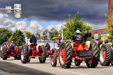 A group of farmers with their tractors. The Thai for "a group of farmers with their tractors" is "กลุ่มเกษตรกรกับรถแทรกเตอร์ของพวกเขา".