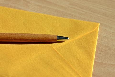 A pen on a yellow envelope. The Thai for "a pen on a yellow envelope" is "ปากกาบนซองจดหมายสีเหลือง".
