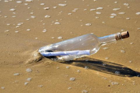 A message in a bottle at the beach. The Thai for "a message in a bottle at the beach" is "ข้อความในขวดที่ชายหาด".