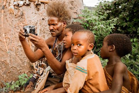 Children with a man and a camera. The Thai for "children with a man and a camera" is "เด็กๆกับผู้ชายและกล้องถ่ายรูป".