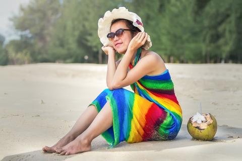 A woman in a rainbow dress with a coconut. The Thai for "a woman in a rainbow dress with a coconut" is "ผู้หญิงในชุดสีรุ้งกับมะพร้าวหนึ่งลูก".