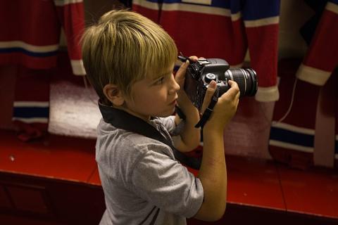 A boy with a camera. The Thai for "a boy with a camera" is "เด็กผู้ชายกับกล้องถ่ายรูป".