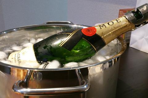 A bottle of champagne in an ice bucket. The Thai for "a bottle of champagne in an ice bucket" is "ขวดแชมเปญในถังน้ำแข็ง".