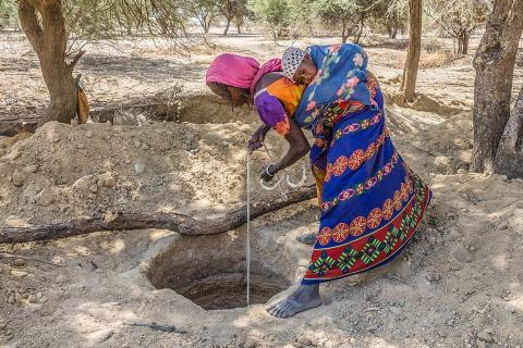 A woman with a baby at a well. The Thai for "a woman with a baby at a well" is "ผู้หญิงกับทารกที่บ่อน้ำ".