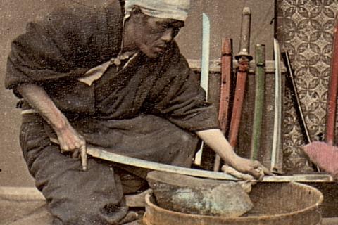 The man is sharpening a sword. The Thai for "the man is sharpening a sword" is "ผู้ชายลับดาบ".