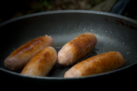Four fried sausages in a frying pan. The Thai for "four fried sausages in a frying pan" is "ไส้กรอกทอดสี่ชิ้นในกระทะ".