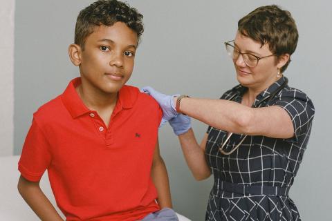 A boy receiving a vaccine. The Thai for "a boy receiving a vaccine" is "เด็กผู้ชายได้รับวัคซีน".