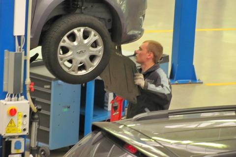 A car mechanic in a repair shop. The Thai for "a car mechanic in a repair shop" is "ช่างซ่อมรถในอู่ซ่อมรถ".