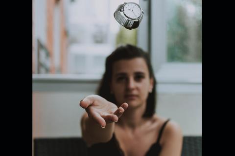 A woman throwing a watch. The Thai for "a woman throwing a watch" is "ผู้หญิงโยนนาฬิกา".