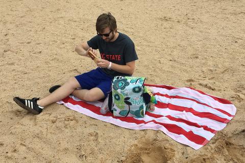 A man having a picnic on the beach. The Thai for "a man having a picnic on the beach" is "ผู้ชายปิกนิกบนชายหาด".