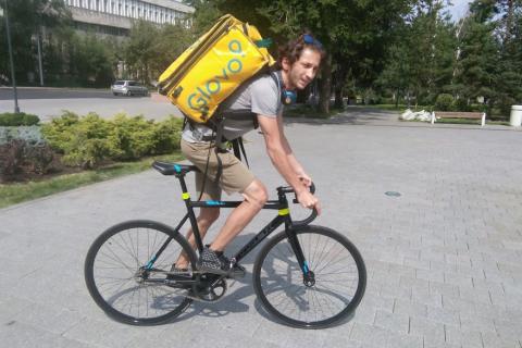 A man carrying a yellow bag on a bicycle. The Thai for "a man carrying a yellow bag on a bicycle" is "ผู้ชายสะพายกระเป๋าสีเหลืองบนจักรยาน".