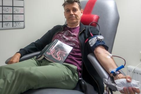 A man donating blood. The Thai for "a man donating blood" is "ผู้ชายบริจาคเลือด".