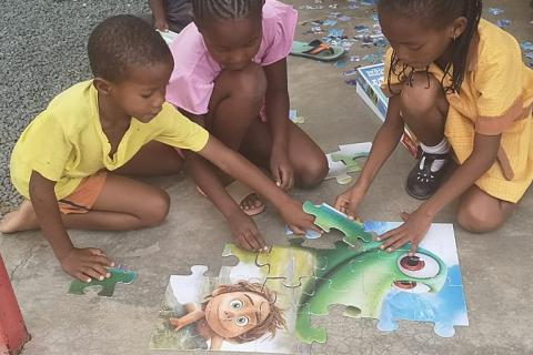 The children are playing with a big jigsaw puzzle. The Thai for "the children are playing with a big jigsaw puzzle" is "เด็กๆเล่นจิ๊กซอว์ใหญ่".