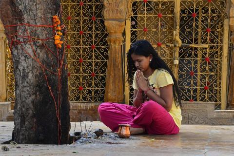 A woman is praying. The Thai for "a woman is praying" is "ผู้หญิงกำลังสวดมนต์".